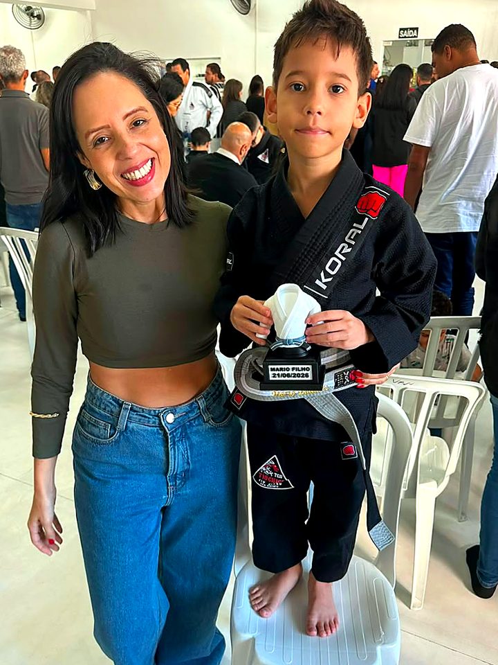 Mãe ao lado do filho que segura o Troféu Kimono