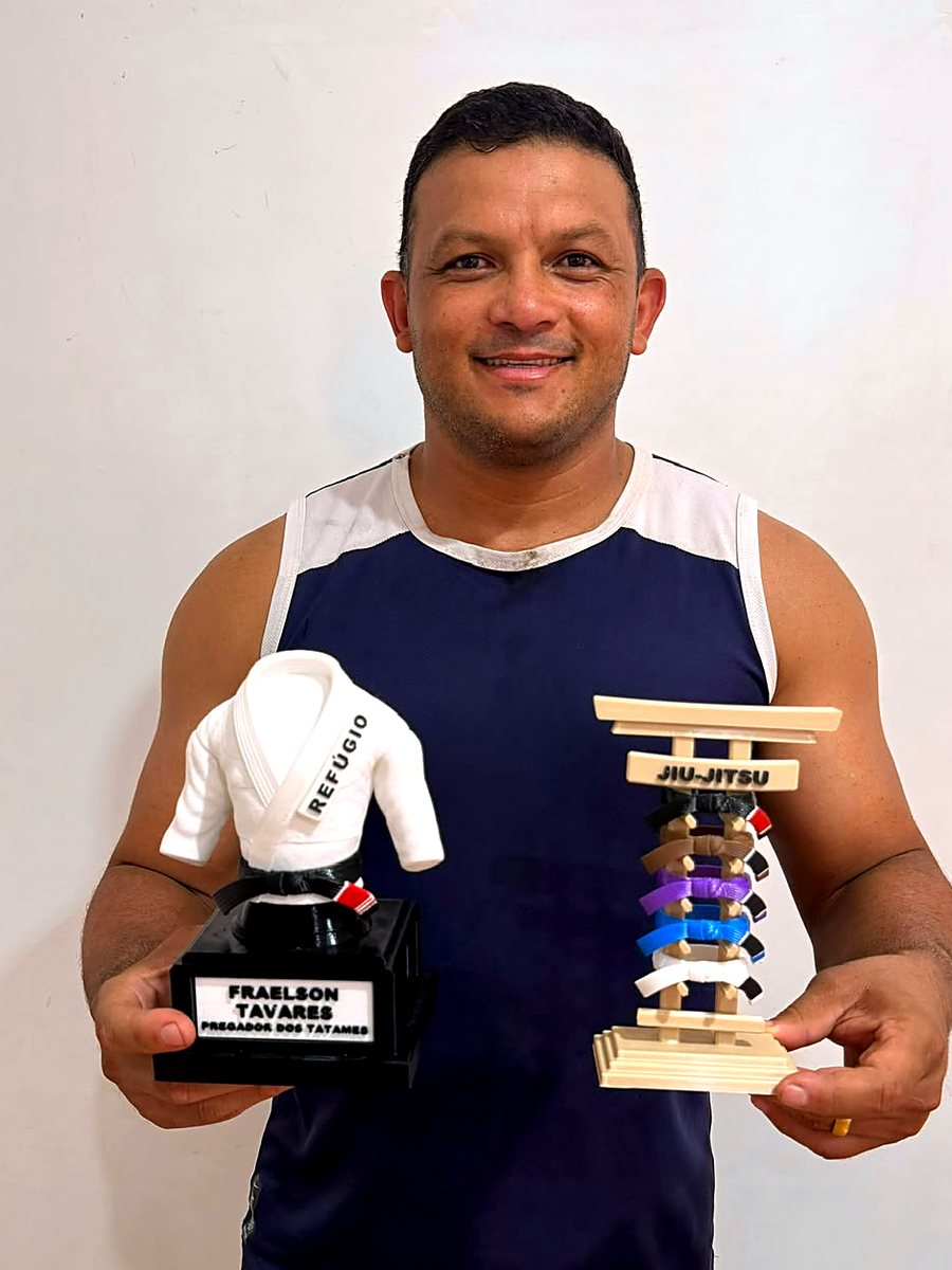 Atleta segurando o troféu de 20 cm com lapela personalizada e o porta-faixa adulto