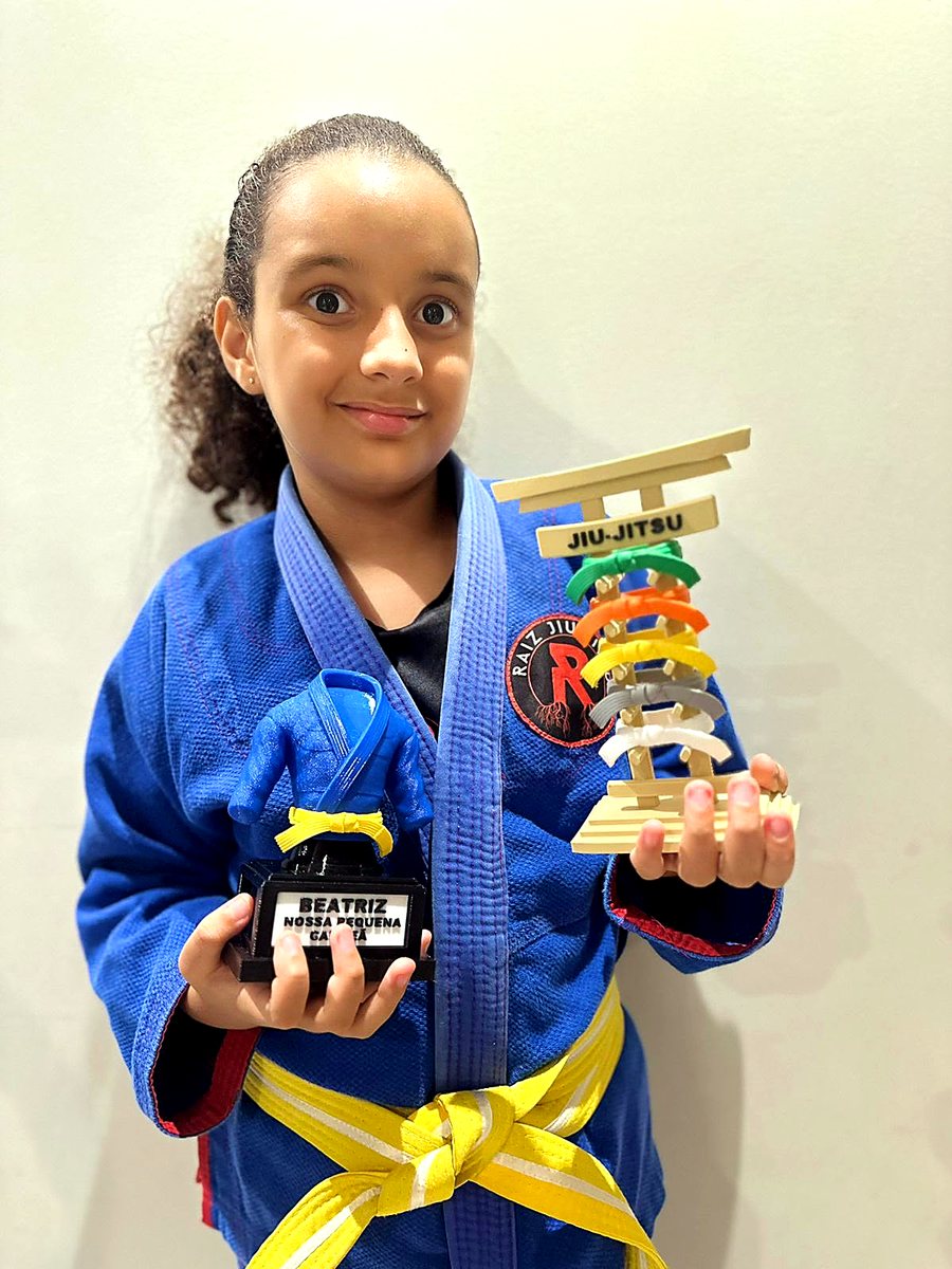 Aluna de faixa amarela com o troféu de 16 cm e o porta-faixa